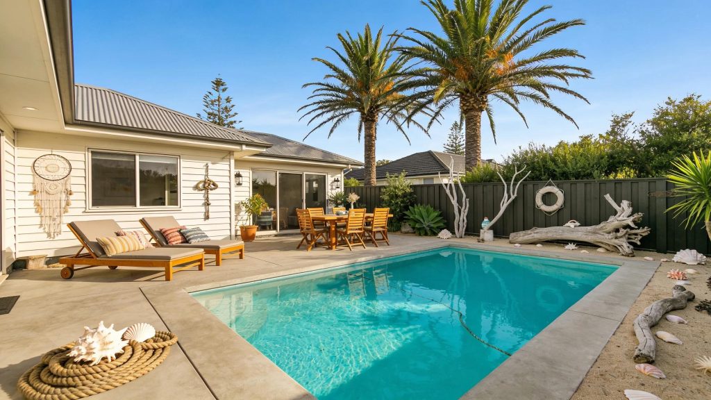 Stylish concrete pool surround in a coastal home with sunny decor