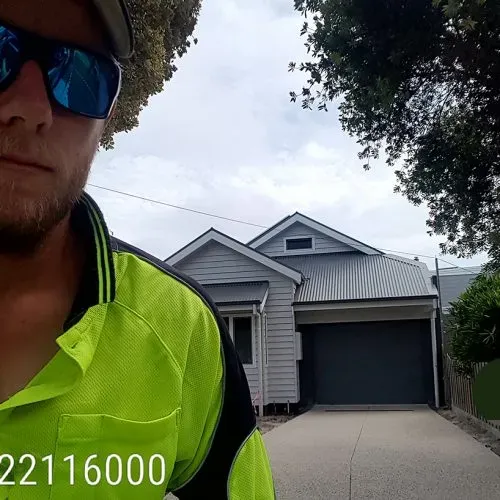 Homeowner maintaining an exposed aggregate driveway, illustrating cleaning and sealing practices essential for longevity
